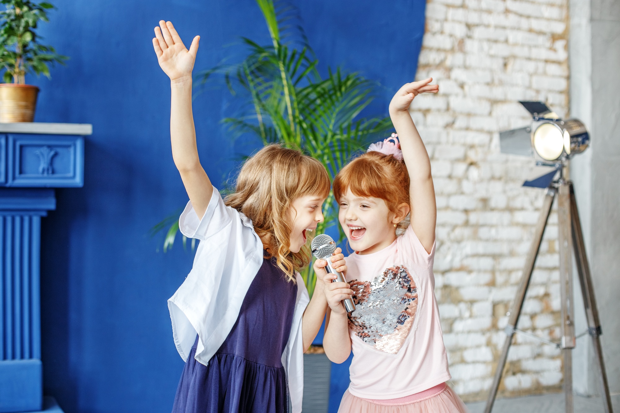Two little funny children dance and sing a song in karaoke. The